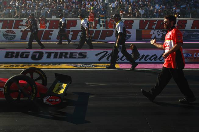 One of Doug Kalitta's crew members helps guide him back to the starting line during the 12th Annual Big O Tires Nationals NHRA drag race on The Strip at Las Vegas Motor SpeedwaySunday, Oct. 28, 2012.
