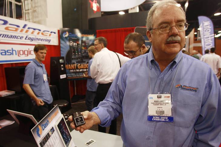 Roger Lemmon from Palmer Performance Engineering displays the module that sends live automotive data to a smart phone or tablet device at the SEMA show Tuesday, Oct. 30, 2012.