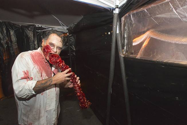 A zombie enjoys a snack in the Haunted Alley during Halloween in downtown Las Vegas Wednesday, October 31, 2012.