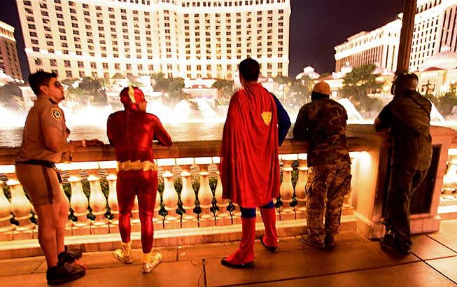 A costumed group out celebrating Halloween pauses to observe the Bellagio Fountains, Oct. 31, 2012. 