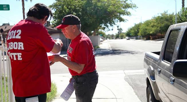 Culinary 226 members Moises Torres checks on his partner's list to make sure they haven't missed a house in the neighborhood they were stationed in on Nevada Day, knocking on doors of potential voters, Oct. 26, 2012.
