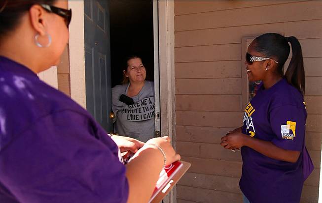 SEIU workers Rasheda Anthony, right, and Yolanda Florian, left, talk to a woman who has already decided to vote for President Barack Obama about the merits of early voting in North Las Vegas, Oct. 27, 2012.