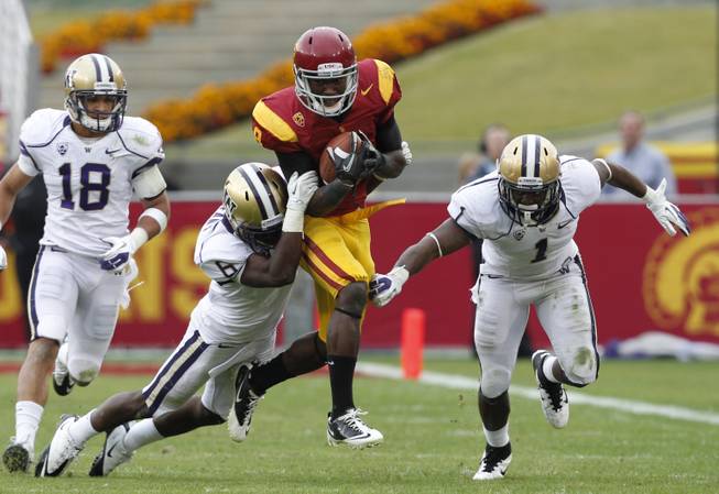 Southern California's Marquise Lee is tackled by Washington's Desmond Trufant after a 14-yard gain in the second half of an NCAA college football game, Saturday, Nov. 12, 2011, in Los Angeles. Southern California won 40-17. 