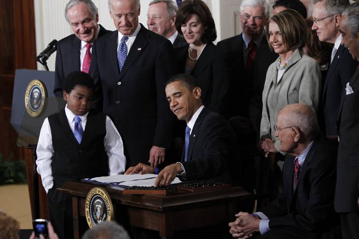 In this March 23, 2010, file photo, President Barack Obama reaches for a pen to sign the health care bill in the East Room of the White House in Washington. 