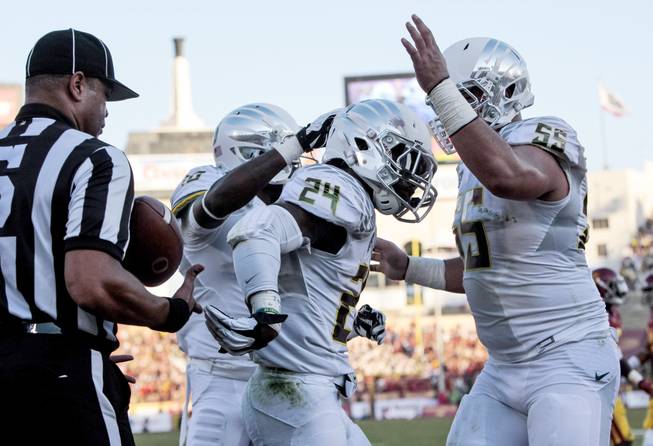 Oregon running back Kenjon Barner (24) celebrates with teammates after scoring a touchdown during the first half of an NCAA college football game against Southern California, Saturday, Nov. 3, 2012, in Los Angeles. Oregon won 62-51.