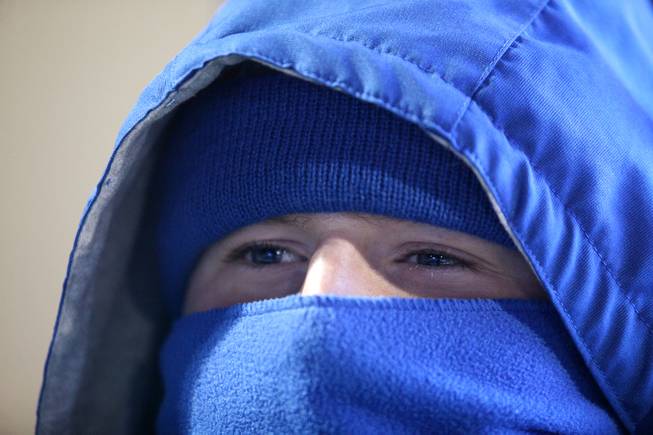 In this file photo, Bishop Gorman student Zachary Robinson tries to stay warm during a 2012 playoff game against Palo Verde. Wet and cold conditions are expected again tonight.



