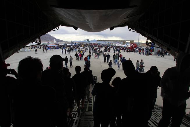 Attendees walk out of the belly of a C5A Galaxy ...