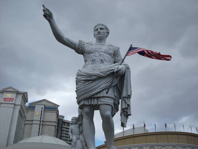 A statue of Caesar Augustus with the American flag welcomes guests at the main entrance of Caesars Palace on Friday, Nov. 9, 2012, in honor of Veterans Day.


