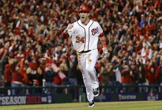 This Oct. 12, 2012 file photo shows Washington Nationals' Bryce Harper reacting as he heads home on a home run by Ryan Zimmerman during the first inning of Game 5 of the National League division baseball series against the St. Louis Cardinals in Washington. 