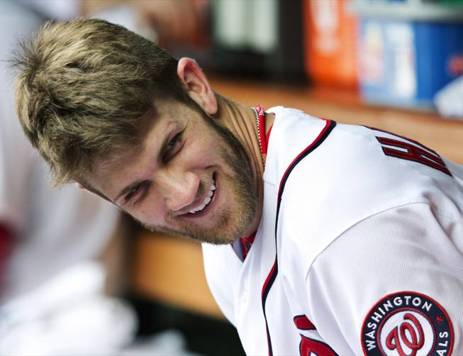 In this Oct. 3, 2012, file photo, Washington Nationals' Bryce Harper smiles as he sits in the dugout during a baseball game against the Philadelphia Phillies in Washington. Harper was named the National League Rookie of the Year Monday, Nov. 12. 