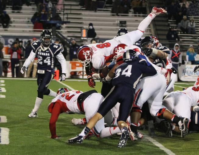 Fresno State's Robbie Rouse jumps over UNR's defensive line to score in the Bulldogs' 52-36 victory in Reno.