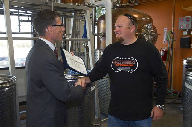 Congressman Joe Heck (R-NV), left, presents a certificate of recognition to Justin Wallin, owner of Booze Brothers Beverage, during the Historic First Edition Day at the Las Vegas Distillery in Henderson Saturday, November 17, 2012. The event marks the first bottling of several new spirits and the grand opening of the Booze Brothers  distribution company and the Half Full Artisan Shop at the Distillery, a retail store. The spirits include Nevada vodka, whiskey, gin, rum and moonshine.