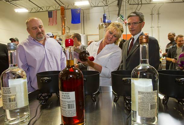 Las Vegas Distillery founder George Racz, left, looks on as Lisa Heck and her husband Congressman Joe Heck (R-NV) wax the top of a Nevada Whiskey bottle during the Historic First Edition Day at the Las Vegas Distillery in Henderson Saturday, November 17, 2012. The event marks the first bottling of several new spirits and the grand opening of the Booze Brothers Beverages distribution company and the Half Full Artisan Shop at the Distillery, a retail store. The spirits include Nevada vodka, whiskey, gin, rum and moonshine.