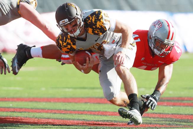 UNLV linebacker Tani Maka misses a tackle of Wyoming quarterback Brett Smith during the first half of their game Saturday, Nov. 17, 2012 at Sam Boyd Stadium.