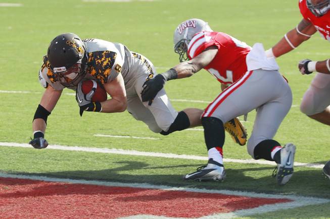 Wyoming running back Brandon Miller dives past UNLV defensive back Peni Vea for a touchdown during the first half of their game Saturday, Nov. 17, 2012 at Sam Boyd Stadium.