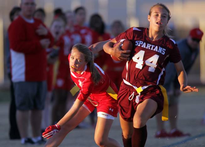 Francesca D'Arienzo, left, of Arbor View watches as Jaymee Luke of Cimarron-Memorial runs with the ball during their girls flag football game at Cimarron-Memorial High School on Monday, November 26, 2012.