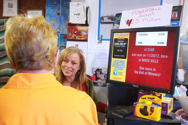 As the jackpot in the multi-state Powerball lottery passes $500 million, Shelia Larson sells tickets to a customer at Rosie's Den in White Hills, Ariz. Tuesday, Nov. 27, 2012.
