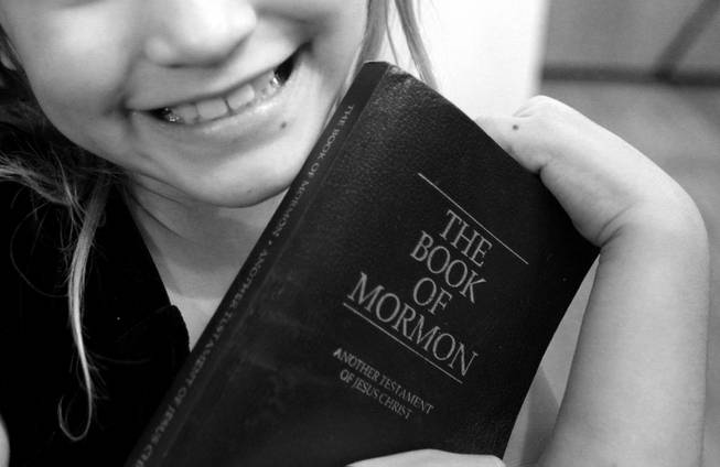 Almalinda Gonzales, 7, shows off her copy of The Book of Mormon at her home in Las Vegas on Wednesday, November 28, 2012.