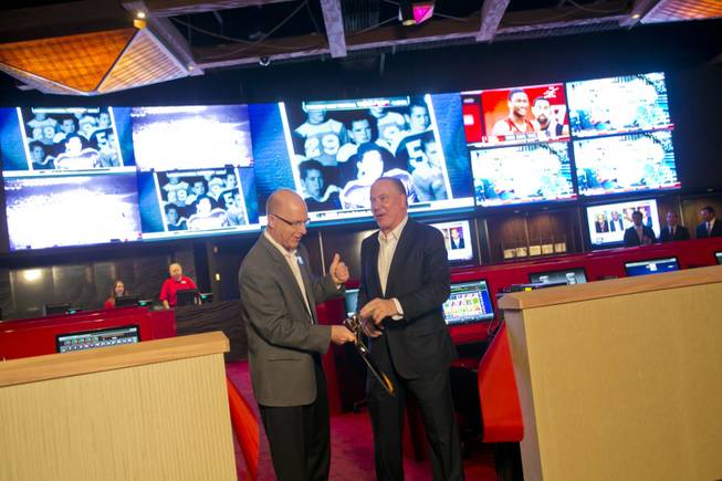 Kirk Golding, VP of Information Technology for Silverton, at left, and Lee Amaitis, President & CEO Cantor Gaming, cut the ceremonial ribbon during the grand opening of The Cantor Sports Book at Silverton, Thursday, Nov. 29, 2012. The 2,000 square-foot sports book features a 2.35 million LED pixel video screen that can show 4 feature sporting events at once.