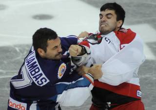 Adam Huxley, right, throws a right hand towards the face of Mike Liambas during a third period fight on Saturday night.