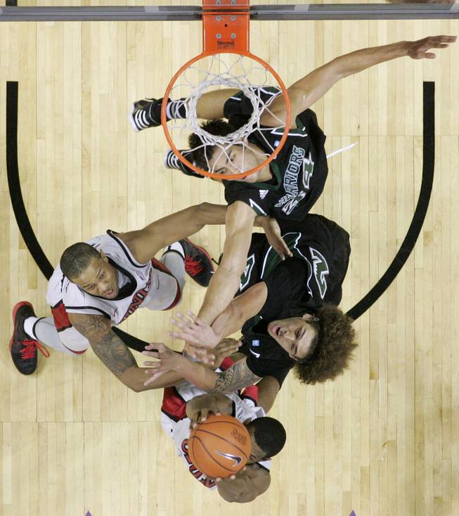 UNLV guard Anthony Marshall grabs a rebound from Hawaii forward Isaac Fotu and guard Michael Harper, top, during their game Saturday, Dec. 1, 2012 at the Thomas & Mack. UNLV won 77-63