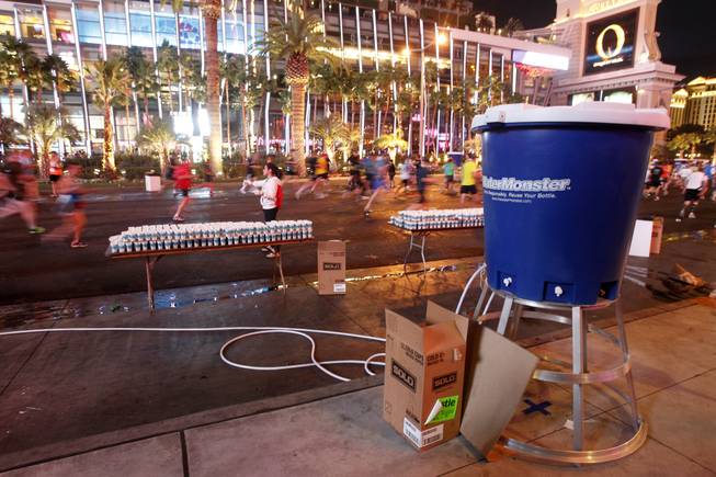 Race workers hand out water during the Zappos.com Rock 'n' Roll Las Vegas Marathon Sunday, Dec. 2, 2012.