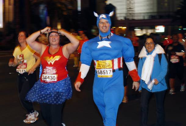 Runners dressed as Wonder Woman and Captain America make their way northbound on the Las vegas Strip during the Zappos.com Rock 'n' Roll Las Vegas Marathon Sunday, Dec. 2, 2012.