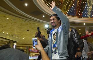 Filipino boxer Manny Pacquiao waves to fans as he leaves the lobby of the MGM Grand Tuesday, December 4, 2012. Pacquiao will take on Juan Manuel Marquez of Mexico in a welterweight bout at the MGM Grand Garden Arena on Saturday. It will be the fourth time for the boxers to fight each other.