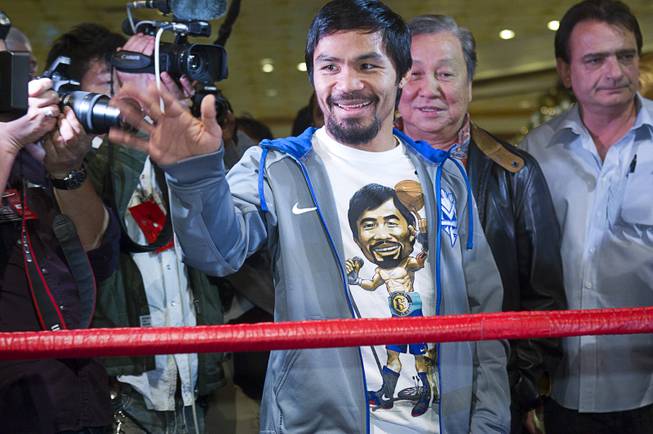 Filipino boxer Manny Pacquiao waves to fans after arriving at the MGM Grand Tuesday, December 4, 2012. Pacquiao will take on Juan Manuel Marquez of Mexico in a welterweight bout at the MGM Grand Garden Arena on Saturday. It will be the fourth time for the boxers to fight each other.