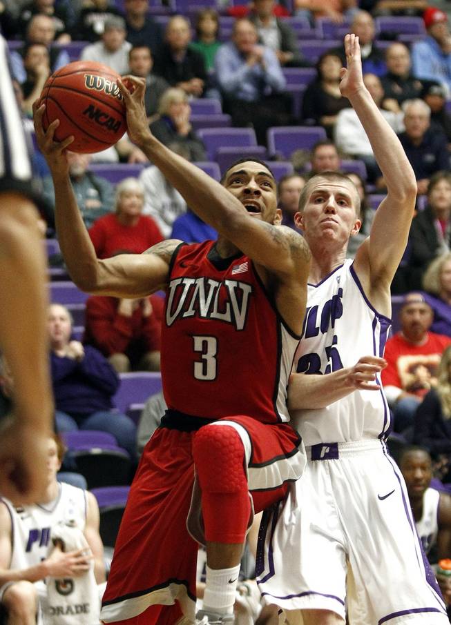 UNLV guard Anthony Marshall, left, goes to the basket past Portland guard David Carr during the first half of a game in Portland, Ore., Tuesday, Dec. 4, 2012. 
