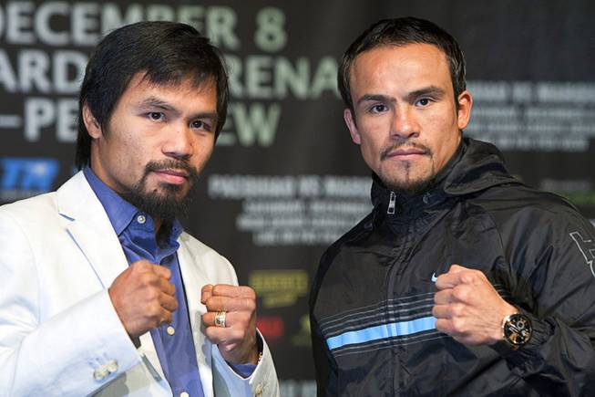 Filipino boxer Manny Pacquiao, left, and Juan Manuel Marquez of Mexico pose during a news conference at the MGM Grand Wednesday, Dec. 5, 2012. Pacquiao and Marquez will fight for a fourth time in a welterweight bout at the MGM Grand Garden Arena Saturday.