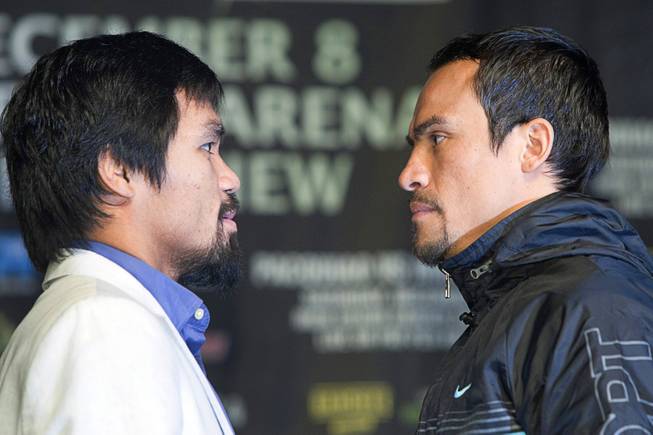 Filipino boxer Manny Pacquiao, left, and Juan Manuel Marquez of Mexico face off during a news conference at the MGM Grand Wednesday, Dec. 5, 2012. Pacquiao and Marquez will fight for a fourth time in a welterweight bout at the MGM Grand Garden Arena Saturday.