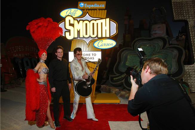 Showgirl Jennifer Autry and Elvis impersonator Brendan Paul pose for a photo with contest winner Jeff Paul during an event to honor Paul who won an Expedia.ca contest Thursday, Dec. 6, 2012 at the Neon Museum.