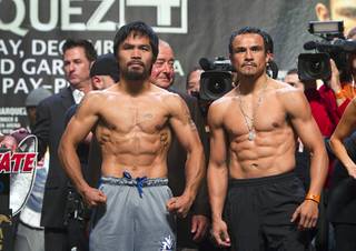 Filipino boxer Manny Pacquiao, left, and Juan Manuel Marquez of Mexico pose during an official weigh-in at the MGM Grand Garden Arena Friday, Dec. 7, 2012. Pacquiao and Marquez will fight for the fourth time in a welterweight bout at the arena on Saturday.