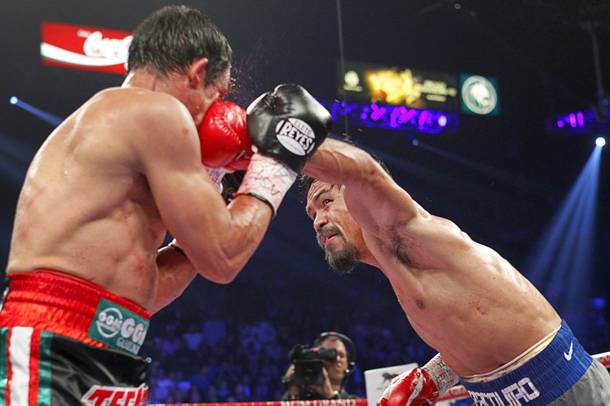 Manny Pacquiao (R) of the Philippines lands a punch on Juan Manuel Marquez of Mexico during their welterweight fight at the MGM Grand Garden Arena in Las Vegas, Nevada December 8, 2012. Marquez went on to win with a sixth-round knockout.