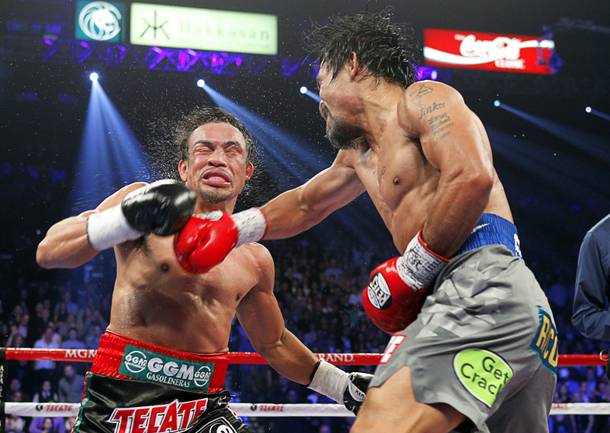 Juan Manuel Marquez (L) of Mexico takes a punch from Manny Pacquiao of the Philippines during their welterweight fight at the MGM Grand Garden Arena in Las Vegas, Nevada December 8, 2012. Marquez went on to win with a sixth-round knockout.