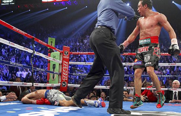 Juan Manuel Marquez is directed to a neutral corner after knocking out Manny Pacquiao during the sixth round of their welterweight fight at MGM Grand Garden Arena on Saturday, Dec. 8, 2012.
