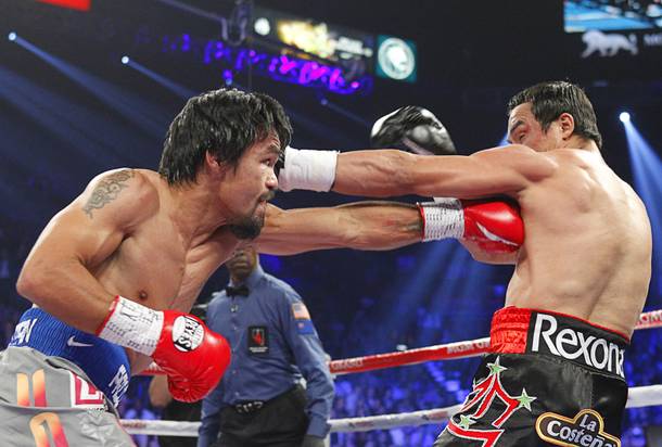 Manny Pacquiao (L) of the Philippines fights Juan Manuel Marquez of Mexico during their welterweight fight at the MGM Grand Garden Arena in Las Vegas, Nevada December 8, 2012.