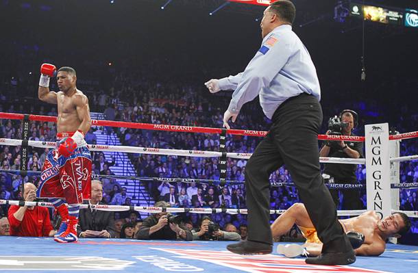 Yuriorkis Gamboa (L) of Cuba is sent to his neutral corner by referee Tony Weeks after knocking down Michael Farenas of the Philippines during their WBA interim super featherweight fight at the MGM Grand Garden Arena in Las Vegas, Nevada December 8, 2012.