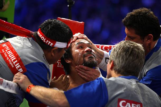 Manny Pacquiao of the Philippines is treated by his corner between rounds during his welterweight fight against Juan Manuel Marquez of Mexico at the MGM Grand Garden Arena in Las Vegas, Nevada December 8, 2012.