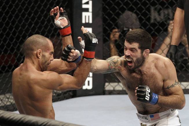 Matt Brown, right, punches Mike Swick in the second round during a welterweight mixed martial arts bout at a UFC on FOX event in Seattle, Saturday, Dec. 8, 2012. Brown won by knockout in the second round.