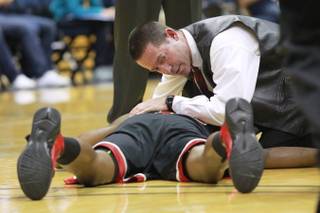 Trainer Dave Tomchek assess UNLV forward Mike Moser's injury during the first half of their game Sunday, Dec. 9, 2012 at Haas Pavilion in Berkeley, Calif. Moser came out of the game with a dislocated elbow. UNLV won 76-75.