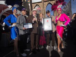 Michael Severino, former Las Vegas Mayor Oscar Goodman, current Las Vegas Mayor Carolyn Goodman and Larry Ruvo pose for a picture with two showgirls at the Start Spreadin the News, fundraiser event held at  New York-New York Hotel & Casino's Brooklyn Bridge,