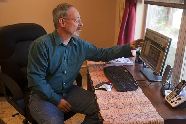 Scott Martin, who lost his hands and feet due to the flesh eating disease, gestures to a computer screen displaying his website at his home Wednesday, Dec. 12, 2012. He wrote a passage for Chicken Soup "Power of Positive" and is working on a memoir.