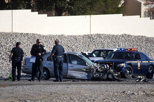 Nevada Highway Patrol troopers investigate an accident involving a Clark County School District school bus and a Honda Accord on Summerlin Parkway westbound near Anasazi Drive Wednesday, Dec. 12, 2012. The Honda was heading eastbound on the parkway when the driver crossed the median and into oncoming traffic, colliding with the bus, troopers said.