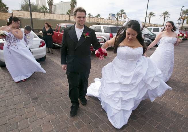 Ryan Maluka, center, his bride Danielle Martinez, and other couples prepare for photos after a group wedding at the Chapel of the Flowers on Las Vegas Boulevard South Wednesday, Dec. 12, 2012. Twelve couples got married at 12:12 pm at the chapel as part of a KOMP 92.3 radio station promotion. Las Vegas wedding chapels were busy all day as many couples wanted to get married on the date of 12-12-12.
