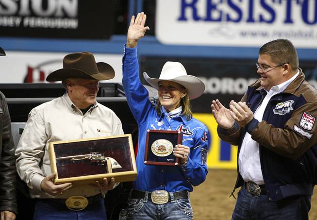 Barrel racer Mary Walker, center, of Ennis, Texas waves after receiving the Ram Truck Top Gun Award during the final night of the Wrangler National Finals Rodeo Saturday, Dec. 15, 2012. Walker won the world title and the Top Gun Award, given to the top earner in a single event at the NFR.