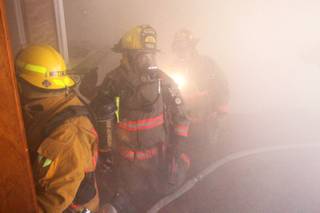 Members of Clark County Fire Department Truck 16 run a search-and-rescue drill inside a home filled with theatrical smoke near McCarran Airport on Monday, Dec. 17, 2012.