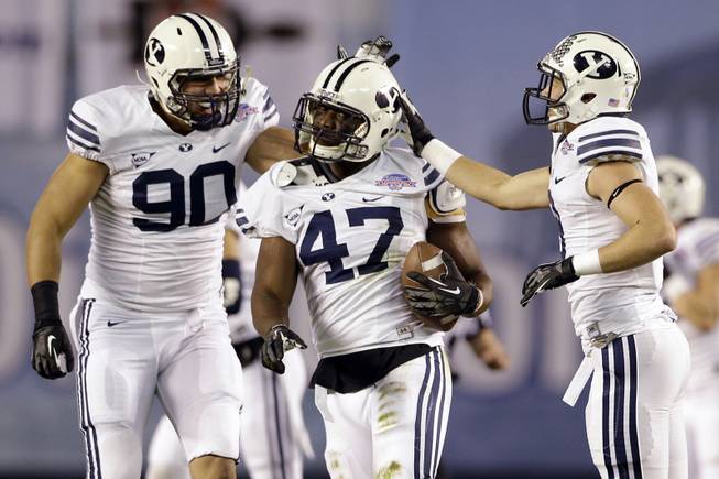 BYU linebacker Ezekiel Ansah, center, is congratulated by Bronson Kaufusi, left, and Daniel Sorensen after intercepting a San Diego State pass during the first half of the Poinsettia Bowl, Thursday, Dec. 20, 2012, in San Diego. 