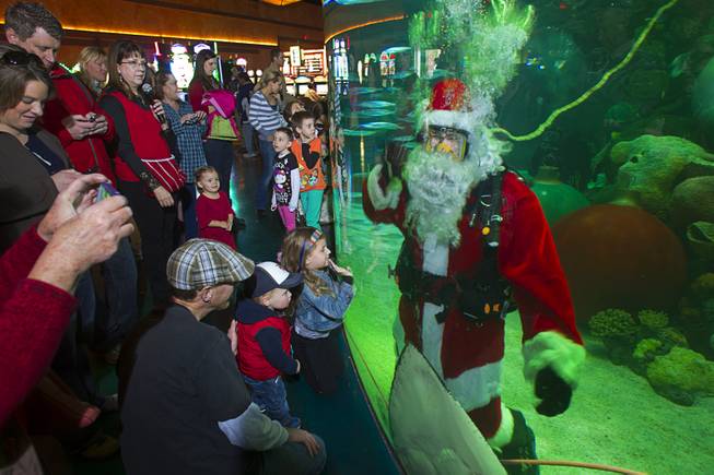 Santa waves to children from the Silverton's 117,000-gallon aquarium Sunday, Dec. 23, 2012. Santa took Christmas present requests from children using an underwater microphone.